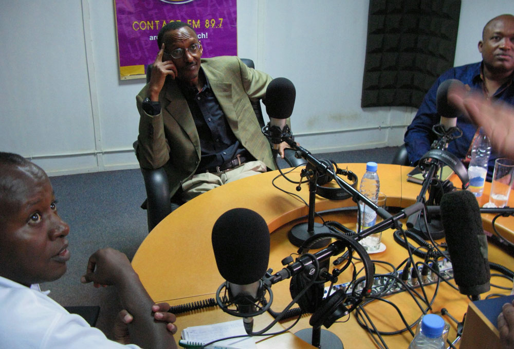 Contact FM's director Albert Rudatsimburwa, unseen, gives the final instructions to roundtable participants Shyaka Kanuma, left and Tom Ndahiro, second from right, and Crossfire news program guest, President Paul Kagame Sept. 13, 2008, at the private radio station's studios.  Photo by Sally Stapleton/GLMI